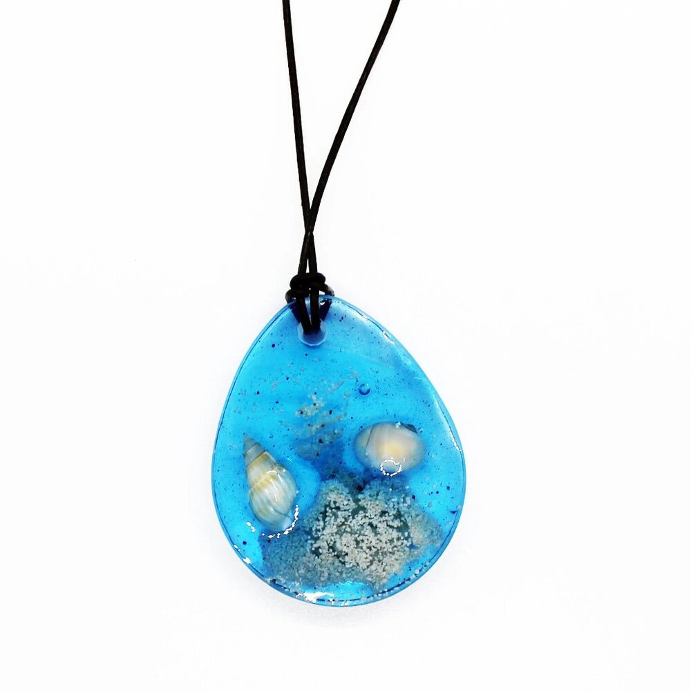 Beachy ocean necklace pendant crafted from beach sand, shells and blue resin